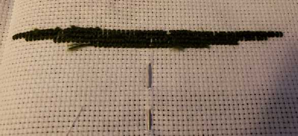 Back side of cross-stitch. The ends of the threads are terminated through the stitches.